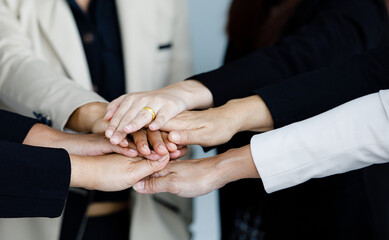 Close up shot of holding hands of unidentified unrecognizable successful female businesswoman group...