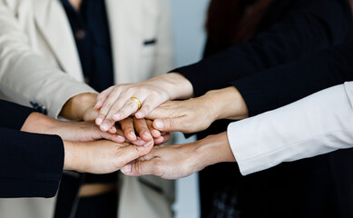 Close up shot of holding hands of unidentified unrecognizable successful female businesswoman group...