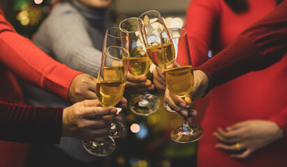 Women on sweater clink glass of ิิbeverage together to start holiday event of jolly drink at gala party for celebrating group success, cheerful relationship