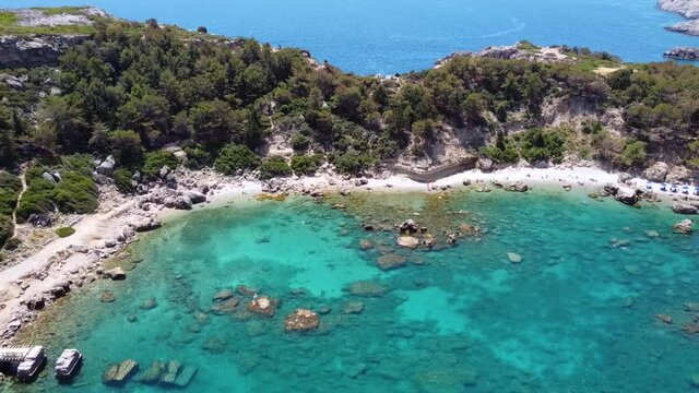 Cinematic drone shot showing breathtaking beach in Greece zooming out from the shore while seaguls passes by.