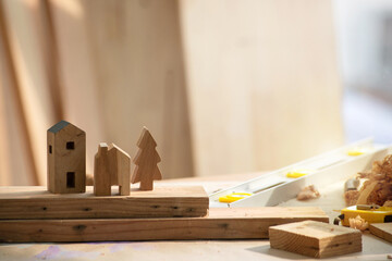Wooden little houses and Christmas tree in workshop studio, DIY wood work, wooden plank in...