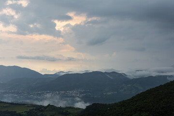 Obraz premium Dramatic image of Caribbean mountains after a rain storm in a small town in Dominican Republic, with cloudy skies and fog.