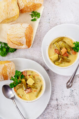 Vegetable soup made from cut green beans, carrot, potato and ham.