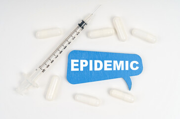 On a white background pills, a syringe and a blue plate with the inscription - EPIDEMIC