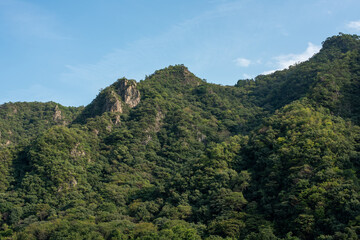 Fototapeta na wymiar 岩肌の見える山と青空