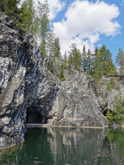 A flooded tunnel in the steep slope of the Marble Canyon in the Ruskeala Mountain Park on a sunny summer day.