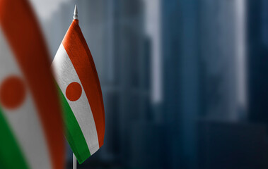 Small flags of Niger on a blurry background of the city - obrazy, fototapety, plakaty