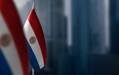 Small flags of Paraguay on a blurry background of the city