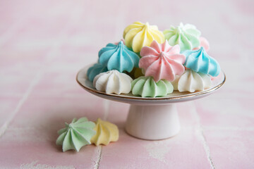 Small colorful meringues on the ceramic  stand