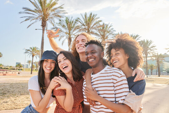 Group of beautiful Caucasian and African-American people having a good time together. Concept of equality, mixed race, young friends, students.