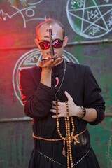 Fototapeta na wymiar A man dressed as a priest. Halloween image. Вlack magic. 