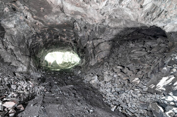 Underground mining, tunnel in the rock. There is a bright light at the end of the tunnel