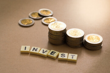 Word "invest" with coins on table.