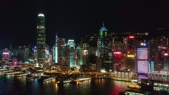Hong Kong island skyline at night, central financial district. Aerial side pan left to right