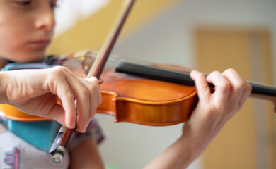 blurred hand of a young violinist holding a bow while playing violins, horizontal