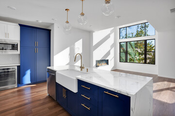 Beautiful kitchen in new luxury home with stainless steel appliances, pendant lights, and hardwood floors