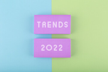 Trends 2022 written on purple rectangles on green and blue background. Concept of newest, latest,...