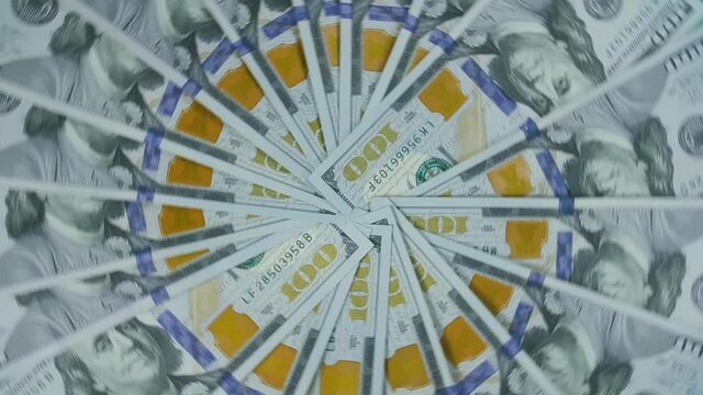 The dollar spin rotate quickly fast fly, dispart, splash to the sides with centrifugal coriolis force. The video is in reverse. Dollar twist, create pattern, make design shape circle picture.