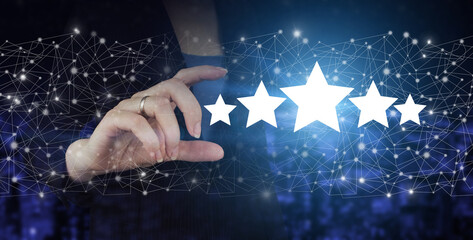Review, Rating,Satisfaction. Hand hold digital hologram five stars sign on city dark blurred...