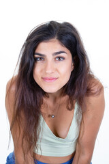 Portrait of pretty smiling young woman standing posing in white wall studio background