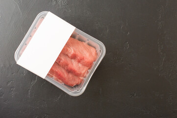 fresh beef steaks in vacuum packaging on a black background. top view. logo layout design.