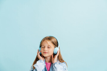 White girl dressed denim jacket listening music with headphones