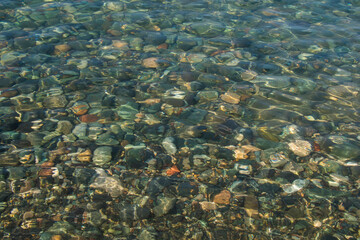 Fototapeta na wymiar Stones in clear water of sea, water background