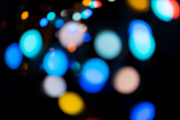 Blur multicoloured defocused glowing bokeh lights of garland on dark background
