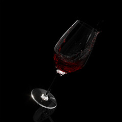 glass of running red wine isolated on black background