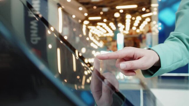 Person using interactive touchscreen display. Concept of modern technology. Person pressing on display while standing near self service terminal.