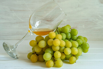 White grape and wine glass on wooden background.