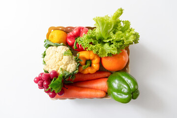 Basket with fresh mixed vegetables on white background