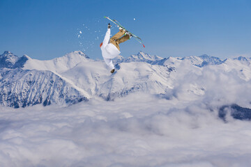 Naklejka na ściany i meble A jumping skier in the mountains. Mountain ski, winter extreme sport.