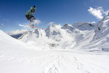 Fototapeta na wymiar A jumping skier in the mountains. Mountain ski, winter extreme sport.