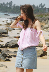 young woman on the beach in summer outfit