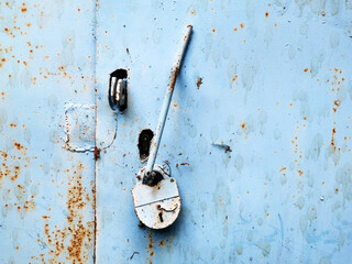 background of very old metal rusty blue garage door with handle and barn lock