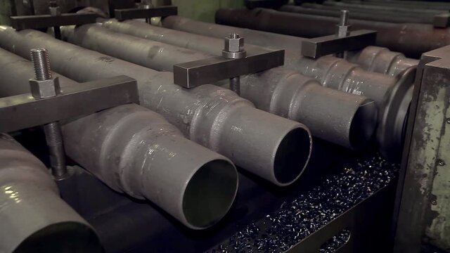 Close-up of a section of steel pipes stacked on top of each other. conveyor production of iron products