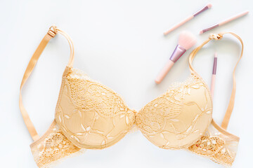 Beige lace bra on white background.