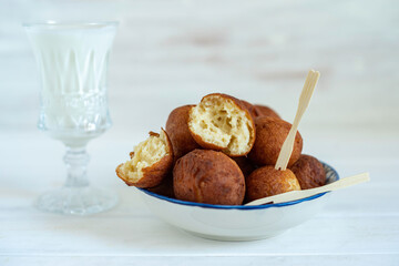 Cottage cheese balls on white wooden background.