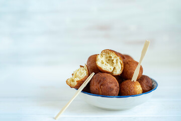 Cottage cheese balls on white wooden background with copy space.