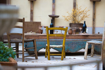Empty outdoor vintage restaurant in winter. Wooden aged table and chairs with bottles and glasses....