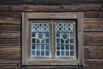 Old leaded window on a log house in a park in Stockholm