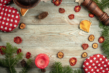 Coniferous branches, festive and kitchen accessories with copy space on a wooden background. Concept of Christmas and New Year. Top view