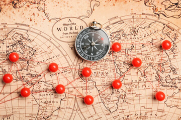 World map with pins and compass, closeup