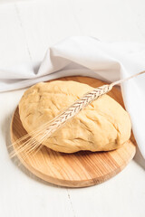 Composition with fresh dough on white wooden background