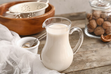 Obraz na płótnie Canvas Jug with tasty walnut milk on kitchen table