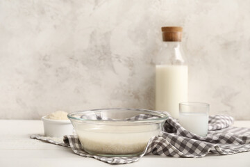 Bowl with tasty rice milk and ingredients on kitchen table
