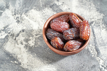 Bowl with dry dates. Top view heap. Healthy sweet snacks. Islamic turkish appetizer. Delicious fresh fruit. Bright background