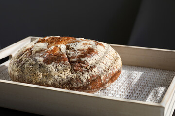 Freshly baked bread on a wooden tray. Country bakery