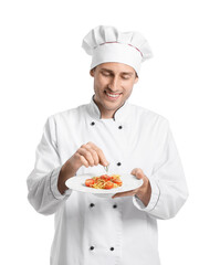 Handsome chef putting rosemary onto plate with pasta on white background